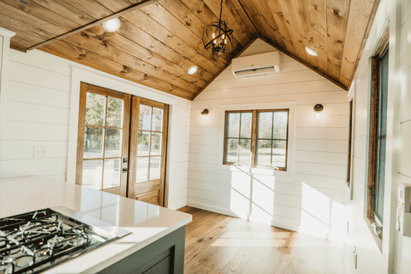 A collection of small, charming tiny homes for sale, each with unique designs, nestled in a scenic outdoor setting.