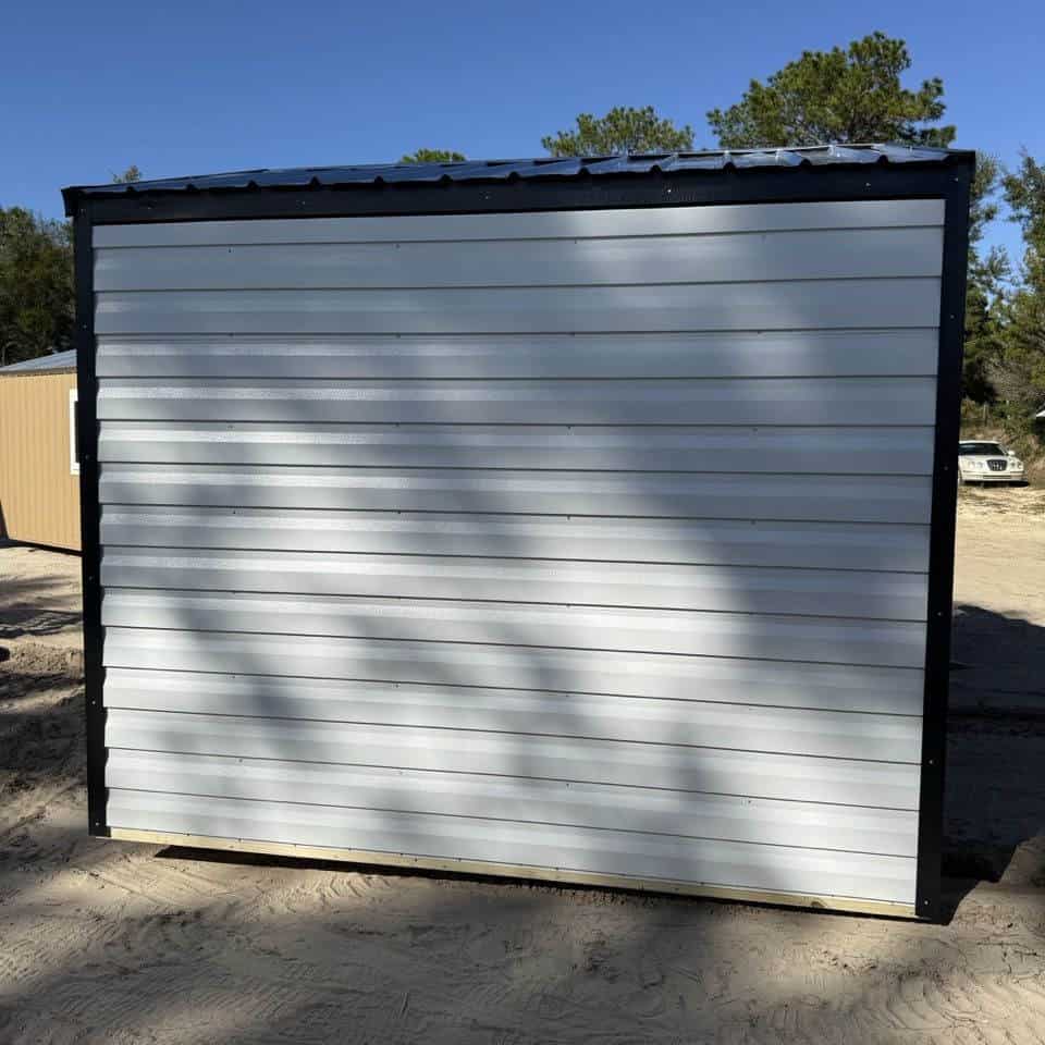 Side view of 10x10 White Steel Americana Shed showing Black trim, Galvalume metal roof, and colonial window