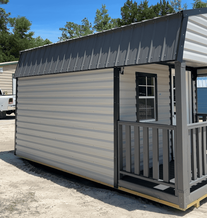 Side view of 10x16 Ash Gray Gambrel Cabin showing Black trim, Charcoal metal roof, 4' porch with rails, and colonial windows