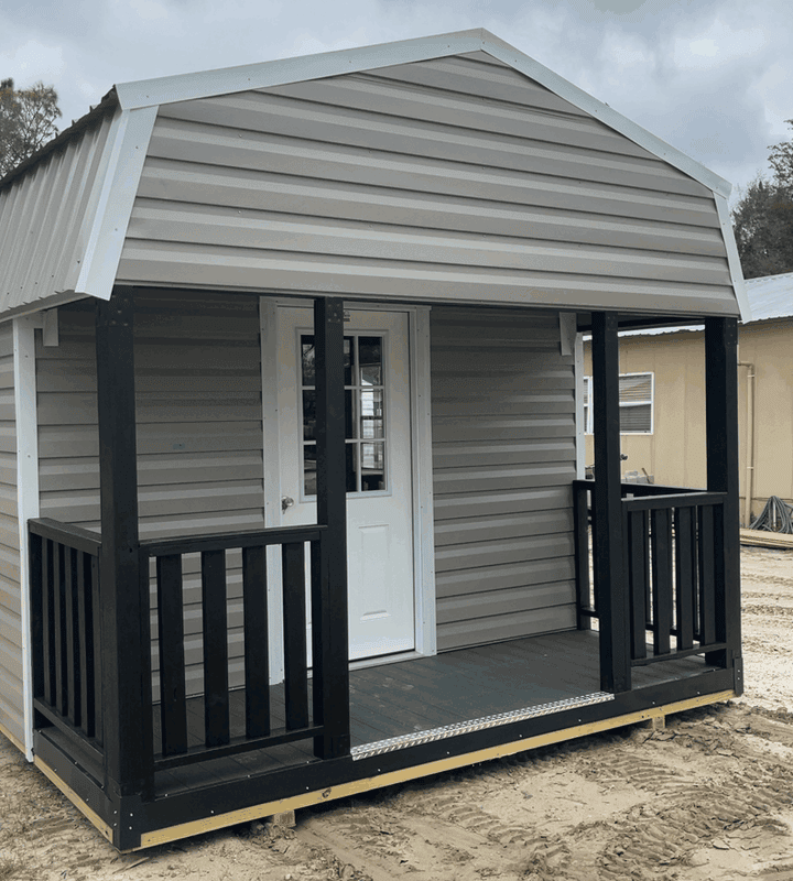 Front view of 12x20 Clay Steel Gambrel Cabin with 4' porch and white rails, 9-lite inswing door, and two colonial windows