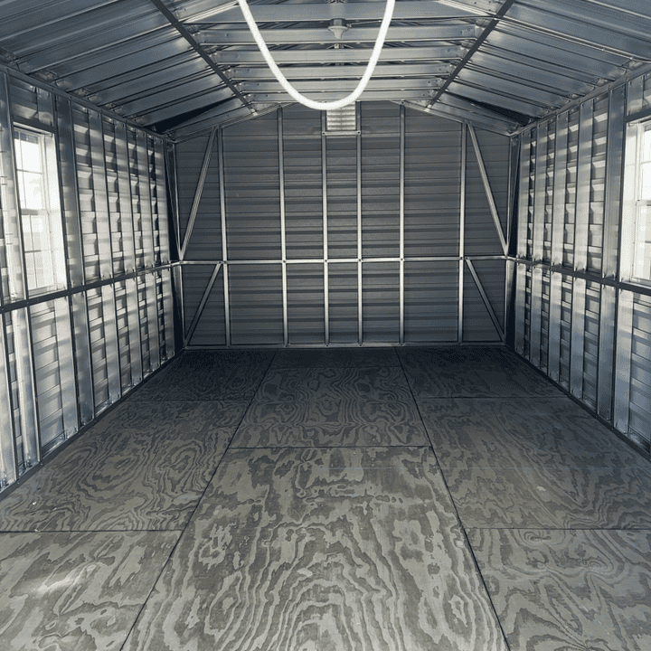Spacious interior of 12x24 steel storage shed showing steel stud walls, 3/4" pressure treated flooring, and pre-wired electrical