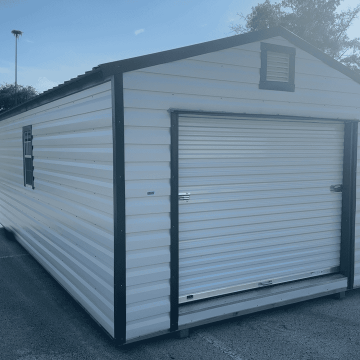 12x24 White R-Lap Steel Shed with Hunter Green metal roof, large roll-up coil door, and two colonial windows