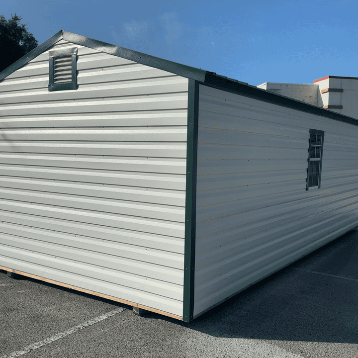 Back view of 12x24 white R-Lap steel storage shed showing Hunter Green roof and two gable vents