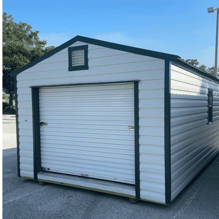 Front of 12x24 white R-Lap steel storage shed featuring large Hunter Green roll-up coil door and two 22x36 windows
