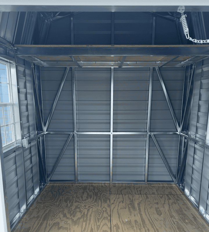 Interior of 8x10 Gambrel Barn with steel stud framing, pressure treated flooring, 4' loft, and natural light from windows