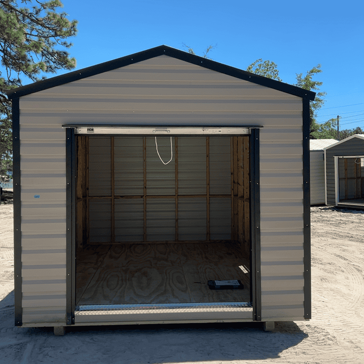 Front view of 10x14 Clay Steel Americana Shed with Black trim and Galvalume roof, featuring 72" roll-up coil door and two colonial windows