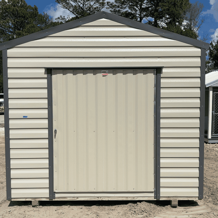Front view of 10x16 Light Stone Steel Americana Shed with Charcoal trim and Galvalume roof, featuring 60" outswing door and two colonial windows
