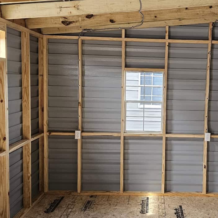 Interior of 10x20 White Vista Shed with wood stud framing, pressure treated flooring, and multiple electrical outlets