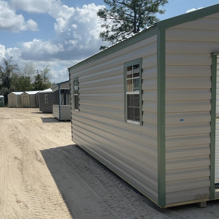Side view of 12x20 Ash Gray Americana Steel Shed with Moss Green trim, colonial windows, and Galvalume roof