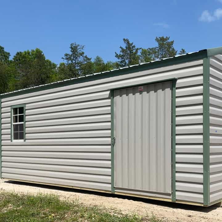 Side view of 12x20 Ash Gray Americana Steel Shed showing 48" Weather-Tite walk-in door, colonial window, and Moss Green trim